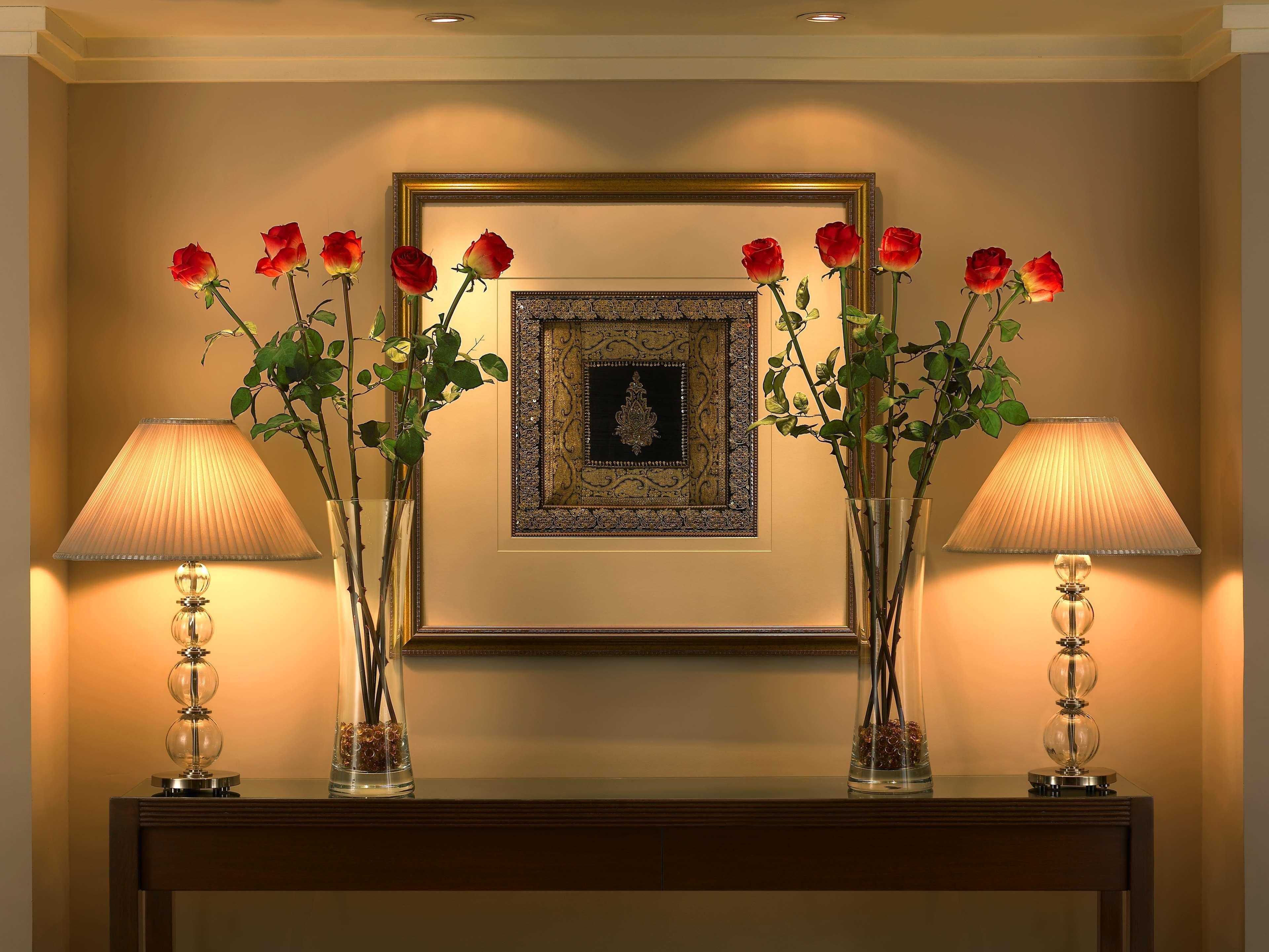 The Leela Mumbai Hotel Exterior photo A console table with a mirror and two lamps